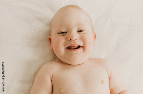 child lying on bed, smiling baby boy