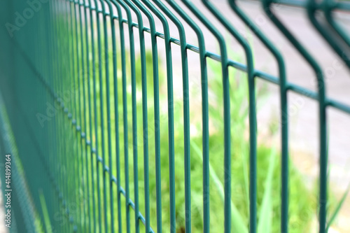 Green steel wire fence with rods. Protecting private property. Selective focus