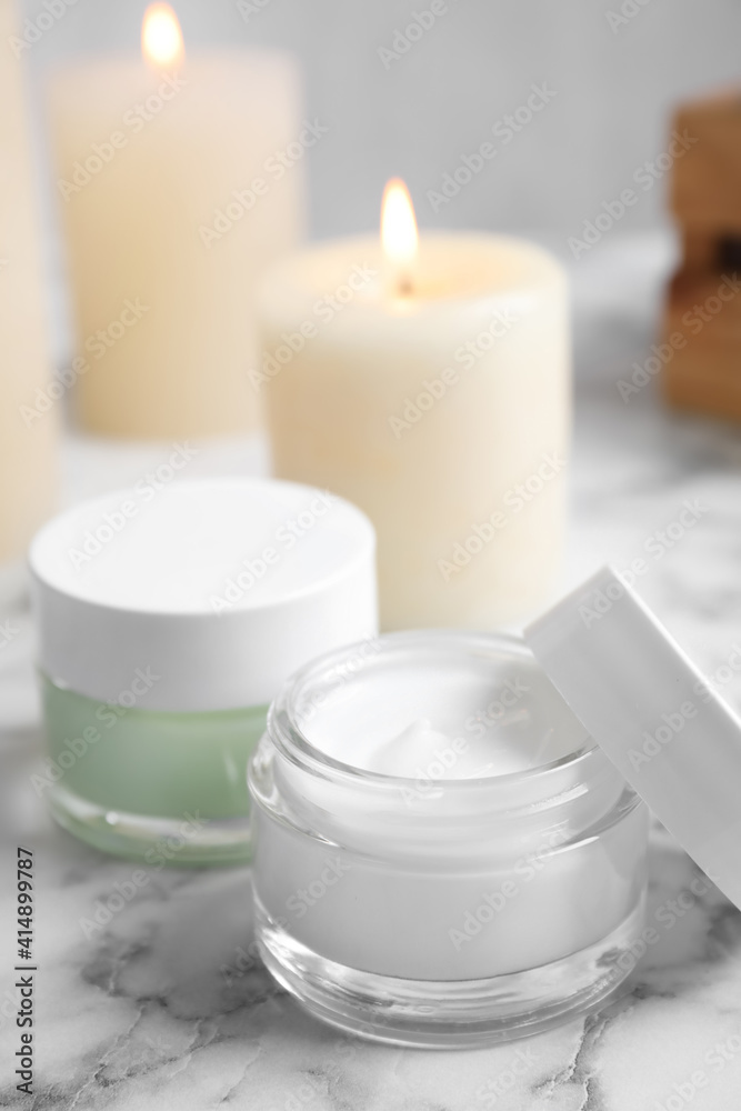 Jars of facial cream on white marble table Jars of facial cream on white marble table