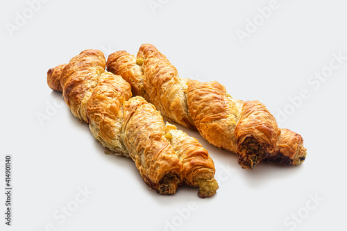 Fresh braided puff pastry bun, with a golden crust on a white background