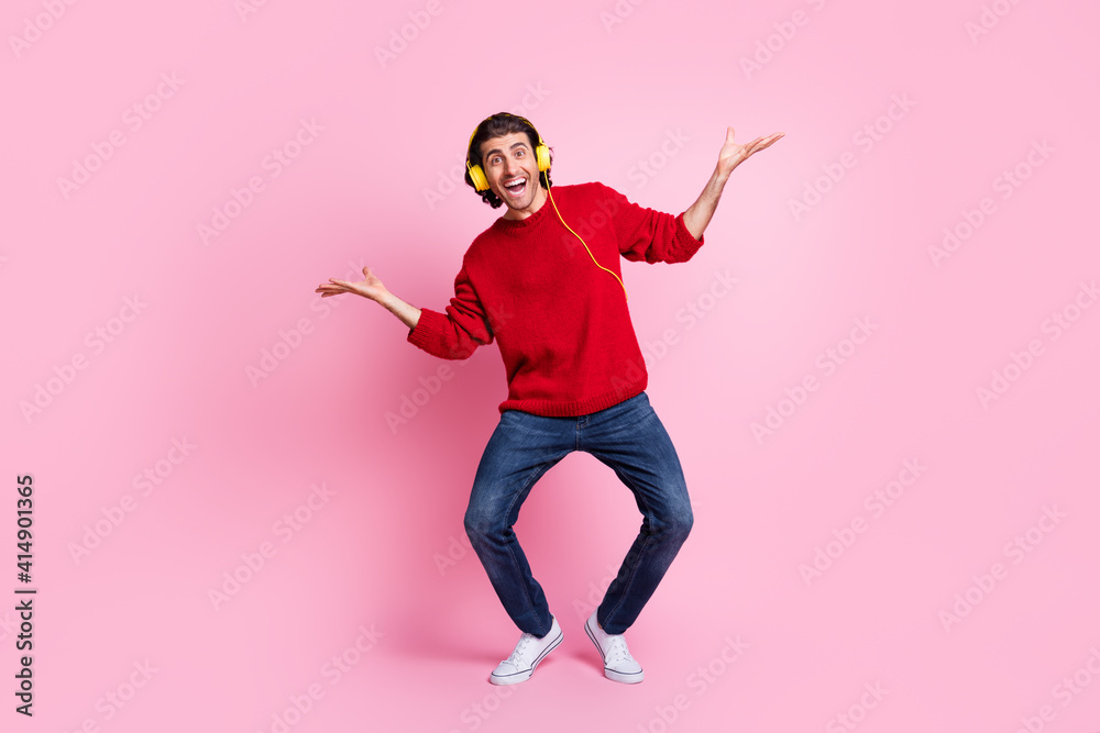 Full size photo of young excited man have fun crazy happy smile enjoy music earphones dance isolated over pink color background