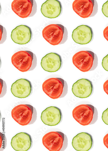 Cucumbers and tomatoes pattern of fresh vegetables sliced 
on a white background