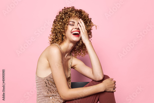 Attractive woman Curly hair sits on a chair smile happiness bright makeup 