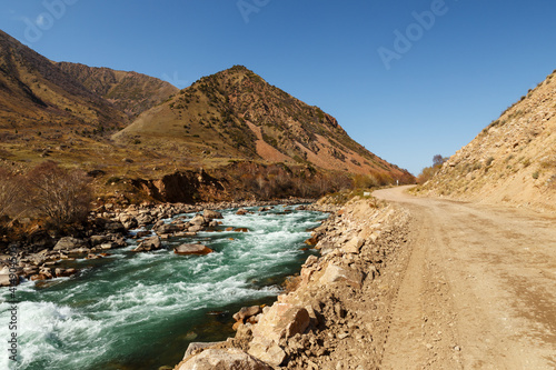 The A367 highway runs along the Kokemeren River in the Jayyl District. Kyrgyzstan.