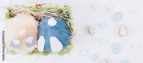 two handmade fluffy easter bunnys and colorful eggs