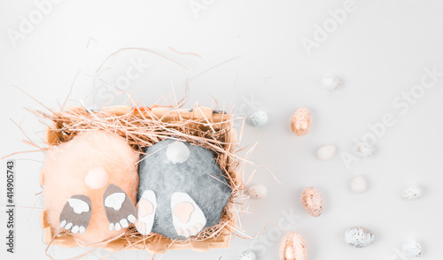 two handmade fluffy easter bunnys and colorful eggs