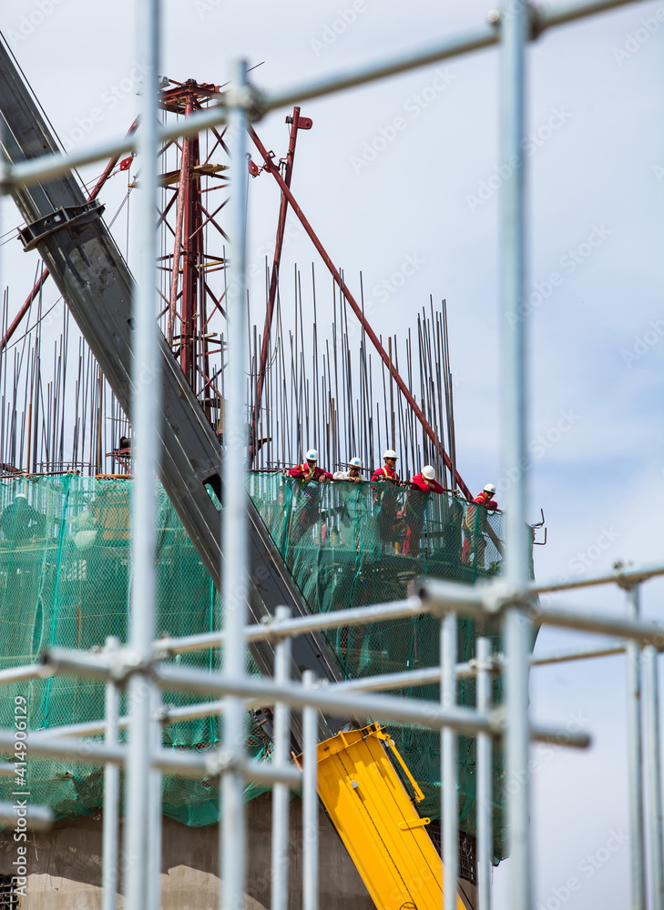 Fototapeta premium Construction workers. Кeinforcement concrete new factory chimney вevelopment. focus on people.