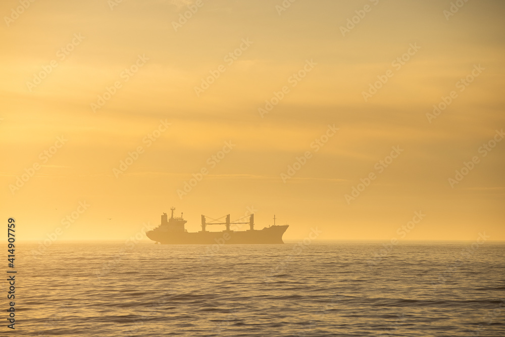 Sunrise by the Black Sea with big transporter ship silhouette