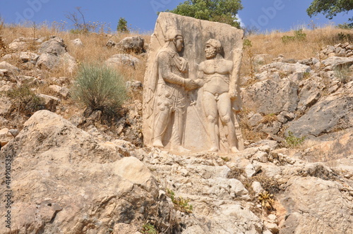 Ancient fortress of Arsameia, the relief showing a hand-shaking scene between King Mithradates and Hercules and stone stairway to a depth of 158 metres, Kahta, Turkey photo