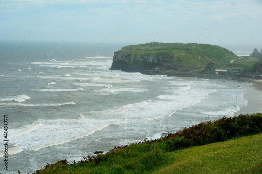 Beautiful shot of the shore washed by ocean waves on a gloomy day in Brazil