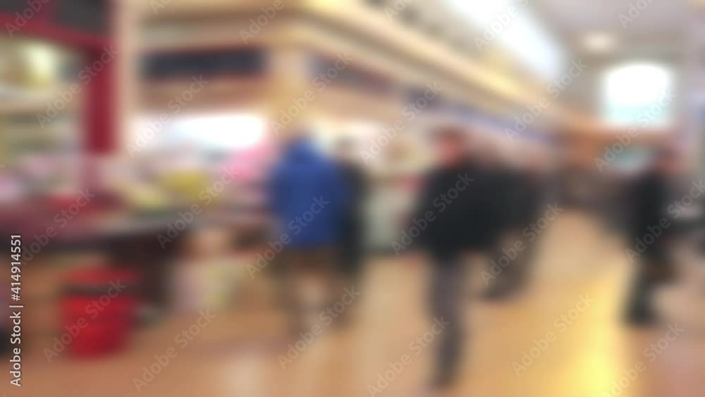 Abstract blurred customers shoppers walking about inside an indoor market Abstract blurred customers shoppers walking about inside an indoor market