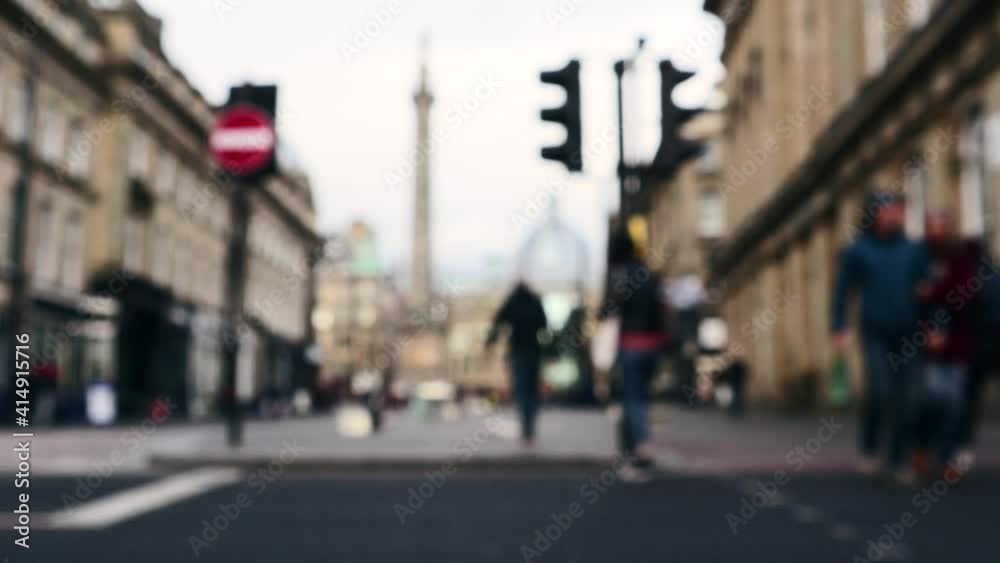 Abstract blurred people crossing a road at a designated pedestrian crossing with traffic lights Abstract blurred people crossing a road at a designated pedestrian crossing with traffic lights