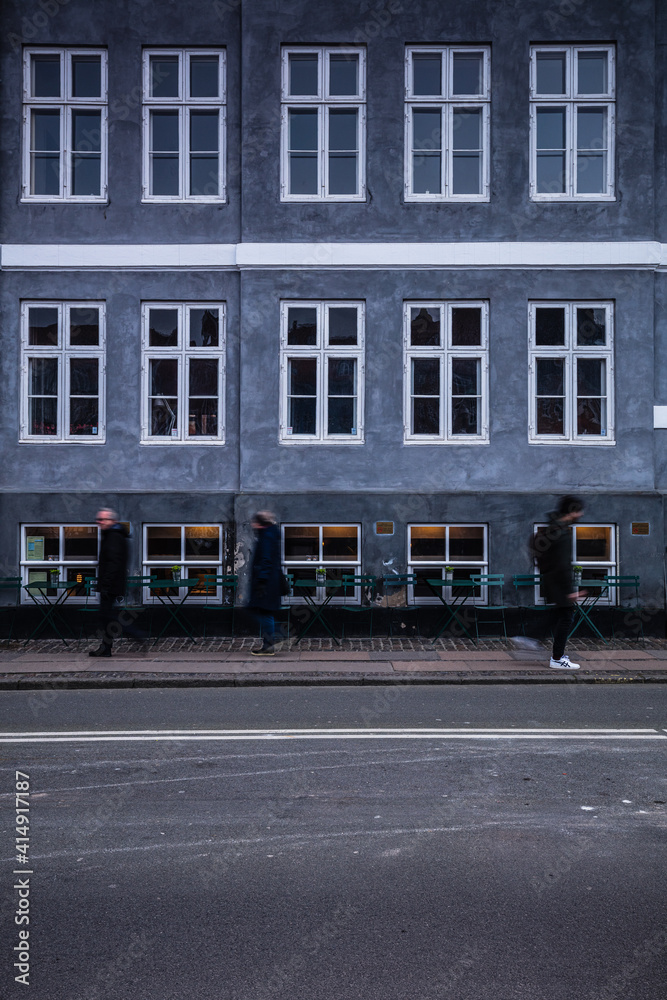 Some people are walking in front of a building in Copenhagen, Denmark, Nord Europe