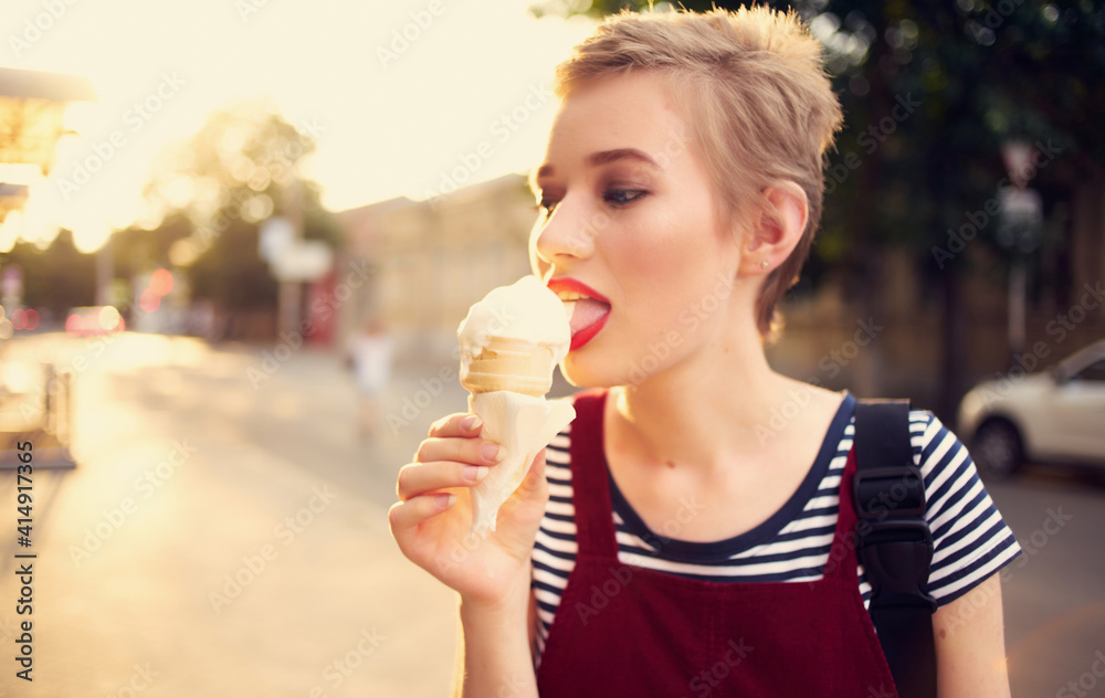 pretty woman with short hair eating ice cream outdoors leisure walk pretty woman with short hair eating ice cream outdoors leisure walk