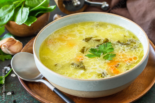 Spring menu. Healthy spinach soup with cream on a dark stone countertop.