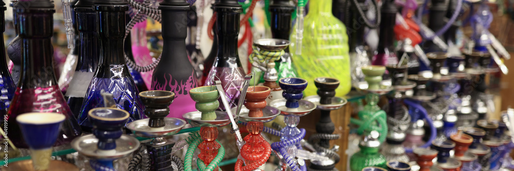 Sale of various types of hookahs. Showcase with smoking equipment in store.
