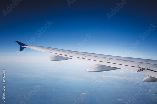 Top view from inside window airplane of blue sky and wing