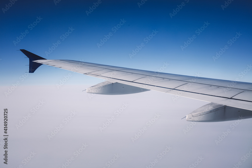 Obraz premium Top view from inside window airplane of blue sky and wing