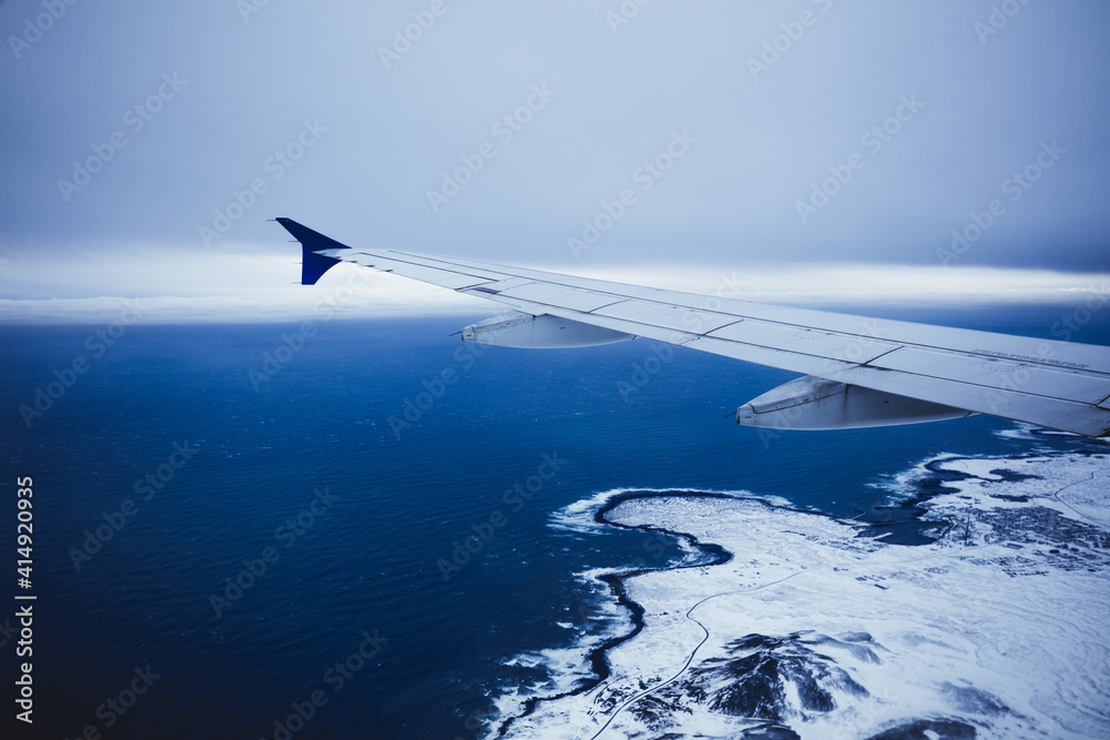 Top view from inside window airplane of a cold atmosphere and wing over Iceland landscape Top view from inside window airplane of a cold atmosphere and wing over Iceland landscape
