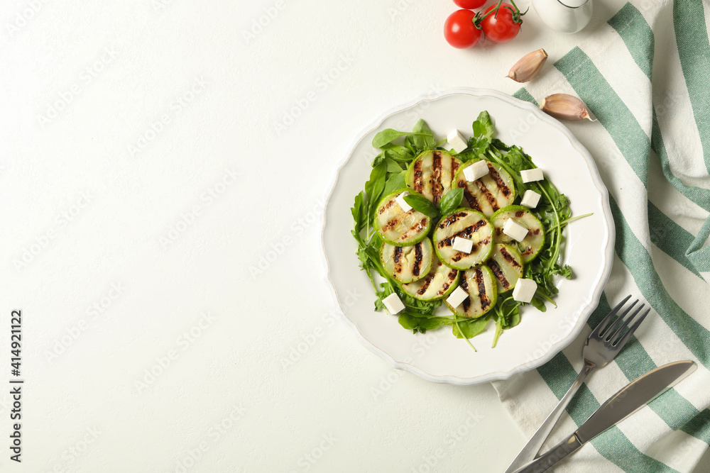 Delicious grilled zucchini slices and feta cheese on white table, flat lay. Space for text Delicious grilled zucchini slices and feta cheese on white table, flat lay. Space for text
