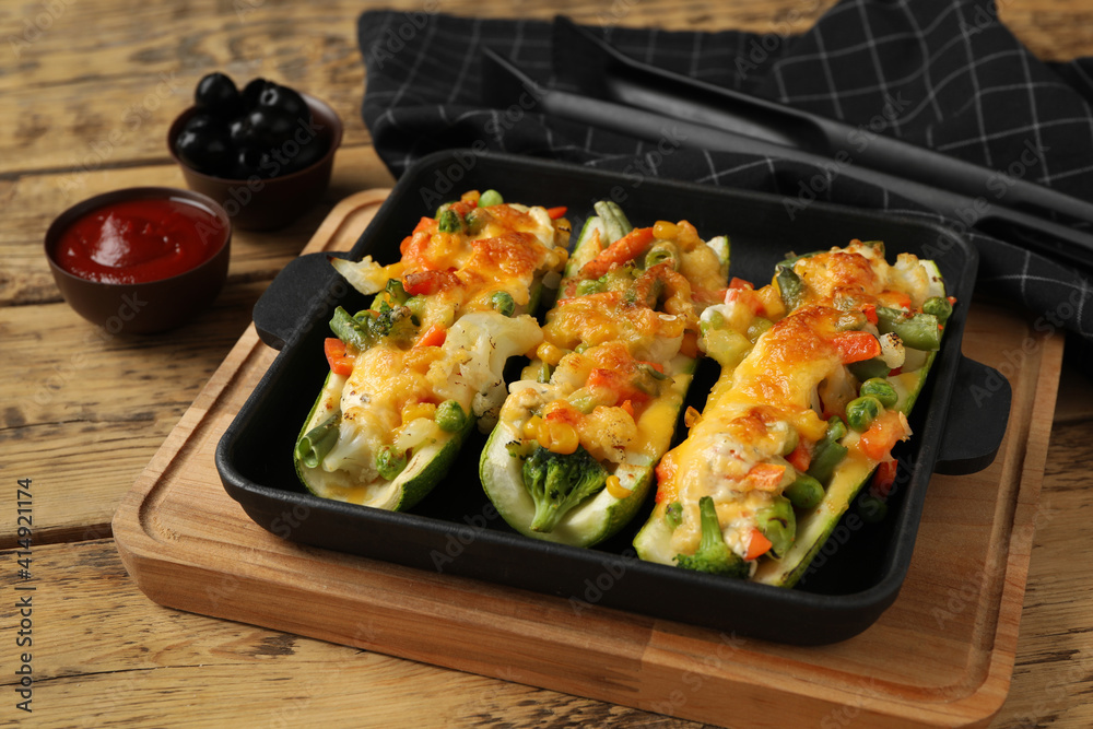 Baked stuffed zucchinis served on wooden table, closeup Baked stuffed zucchinis served on wooden table, closeup