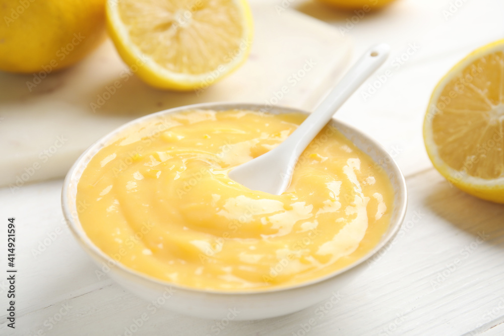 Delicious lemon curd in bowl on white wooden table, closeup Delicious lemon curd in bowl on white wooden table, closeup