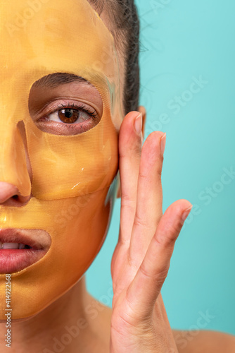 Beautiful woman using facial collagen gel skincare mask treatment