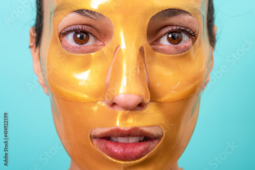 Beautiful woman using facial collagen gel skincare mask treatment