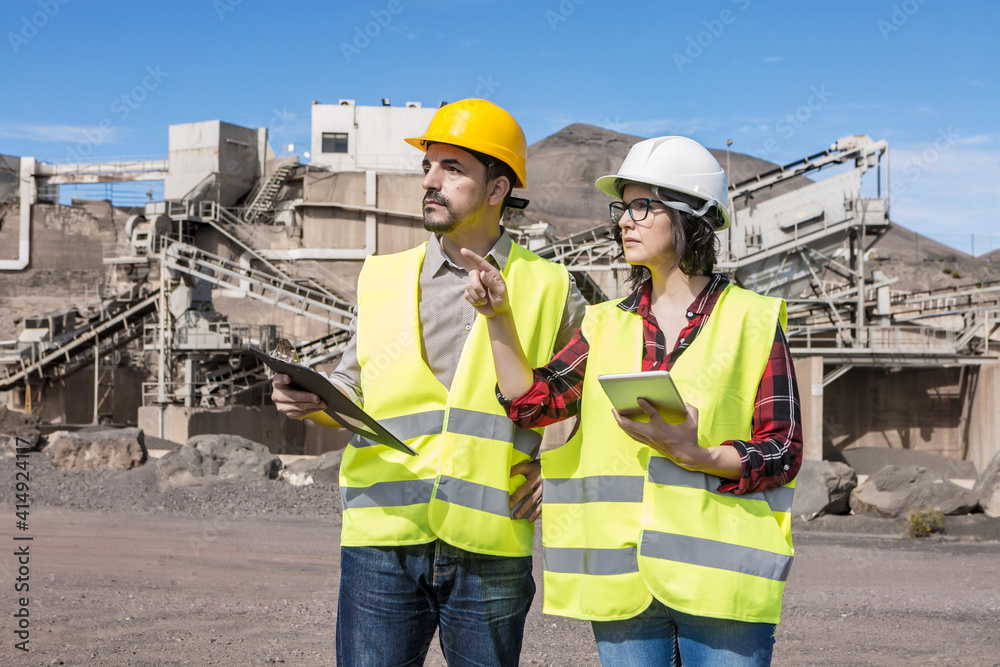 Engineer and inspector with tablet discussing project on construction site Engineer and inspector with tablet discussing project on construction site