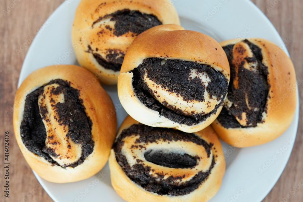 Nahaufnahme vom Mohngebäck aus Hefeteig. Gebäck mit Mohn. Mohnbrötchen. Nahaufnahme vom Mohngebäck aus Hefeteig. Gebäck mit Mohn. Mohnbrötchen.