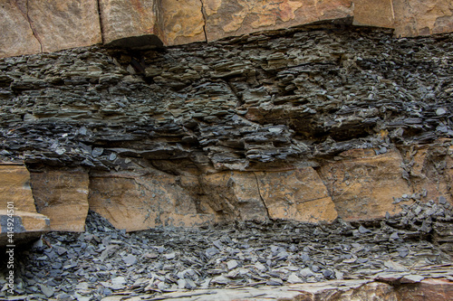 The surface of an old rock with cracks and moss. Old rock texture (wild background)
