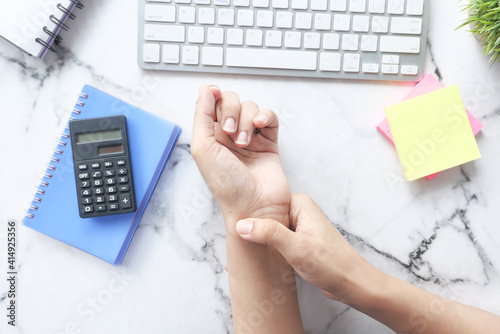  Young women hands suffering wrist pain while working on desk  photo