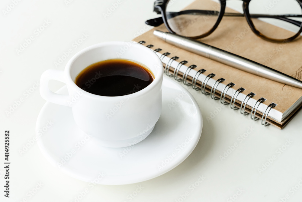 Cup of coffee, glasses, pen and notepad on the table Cup of coffee, glasses, pen and notepad on the table