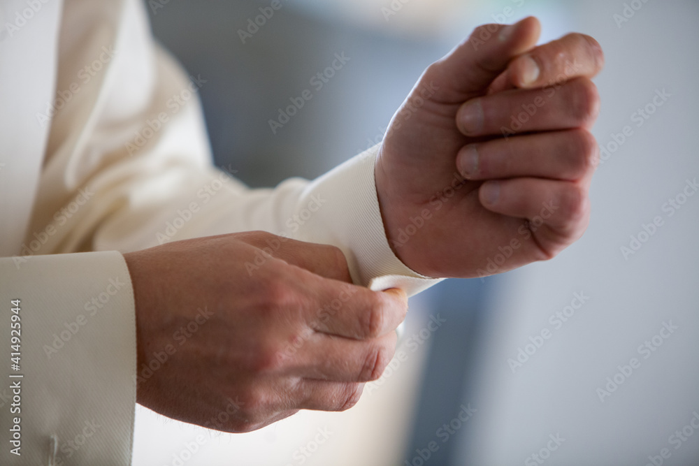 Preparing for wedding. Groom buttoning cufflinks on white shirt before wedding. True men's accessory. Groom's clothes. High quality photo Preparing for wedding. Groom buttoning cufflinks on white shirt before wedding. True men's accessory. Groom's clothes. High quality photo