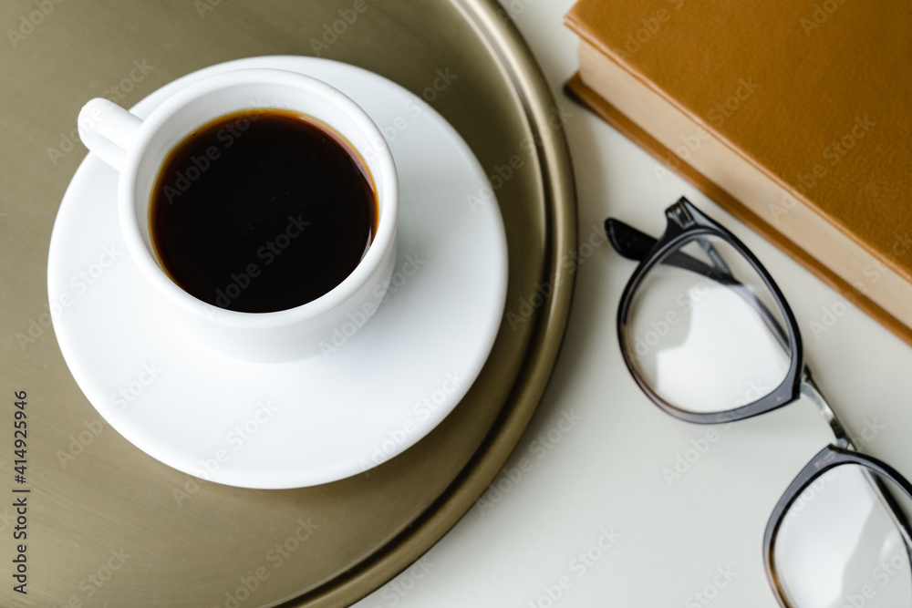Cup of coffee, glasses and book on the table Cup of coffee, glasses and book on the table