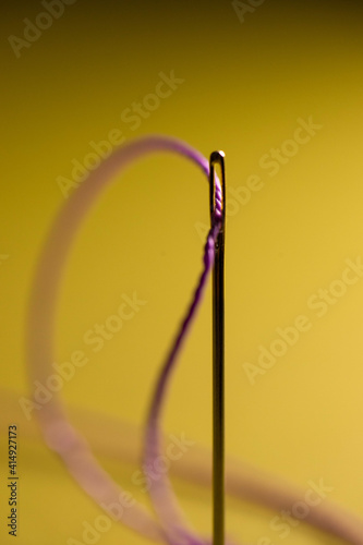 yellow thread in a needle