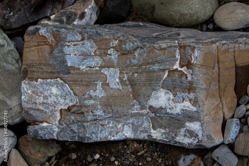 The surface of an old rock with cracks and moss. Old rock texture (wild background)
