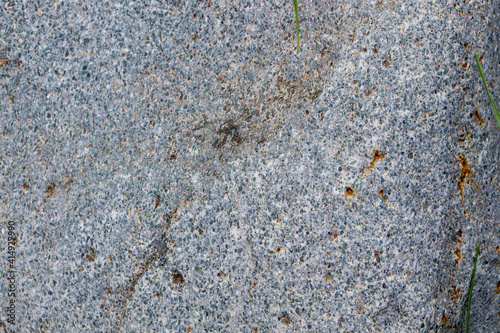 The surface of an old rock with cracks and moss. Old rock texture (wild background)
