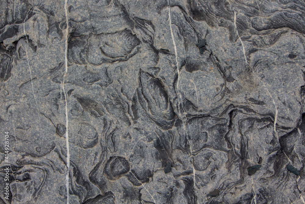 Naklejka premium The surface of an old rock with cracks and moss. Old rock texture (wild background) 