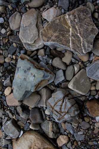 The surface of an old rock with cracks and moss. Old rock texture (wild background)

