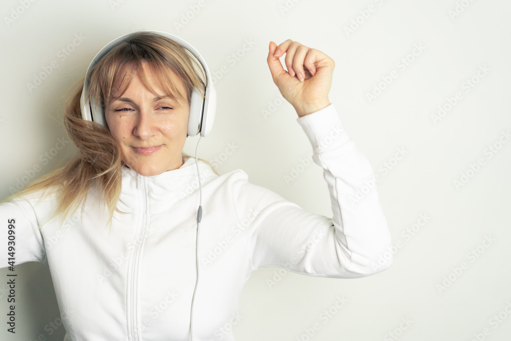 Portrait of smiling pretty woman enjoying music with white headphones on white background Portrait of smiling pretty woman enjoying music with white headphones on white background
