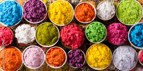 Happy Holi decoration, the indian festival.Top view of colorful holi powder on dark background. photo