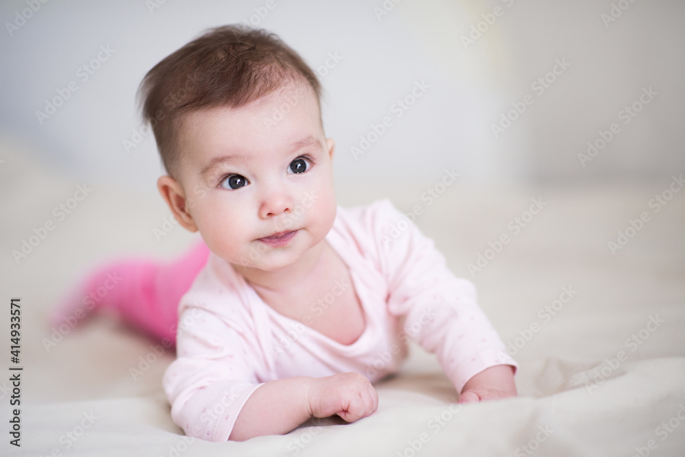 Cute baby under 1 year old wearing pajamas crawling in bed at home close up. Childhood. Good morning. Healthy lifestyle.