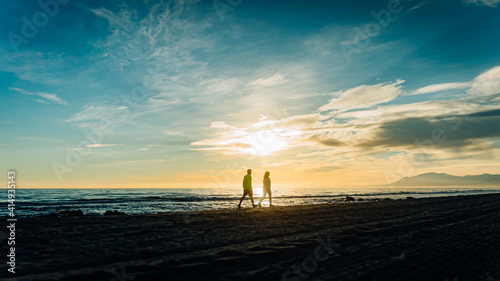 Couple walking at the beach on sunset