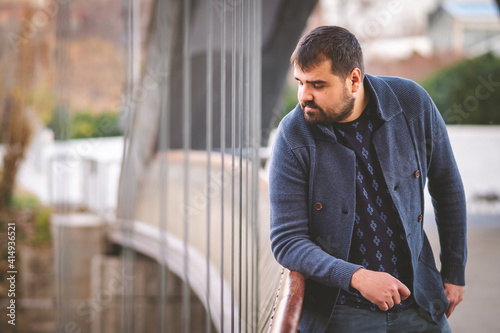 Free Download Mature bearded guy leaning on a railing of a Madrid Bridge at sunset. - GFXLoad