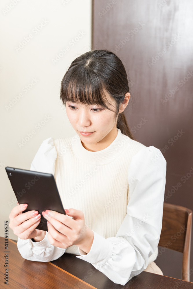 Woman sitting in a chair and holding a tablet Woman sitting in a chair and holding a tablet