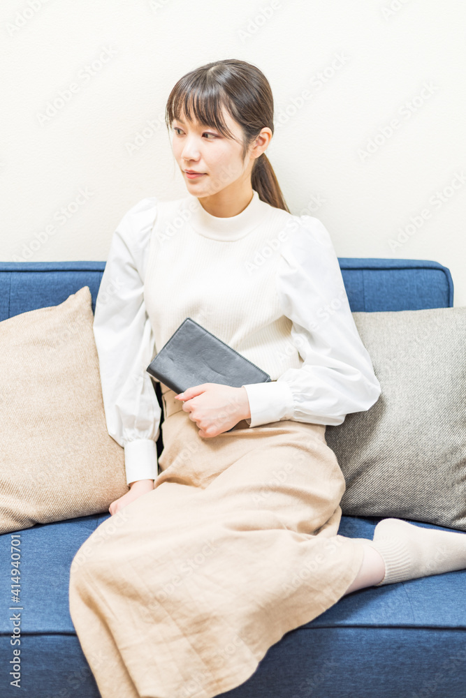 Woman sitting on the couch and holding a book