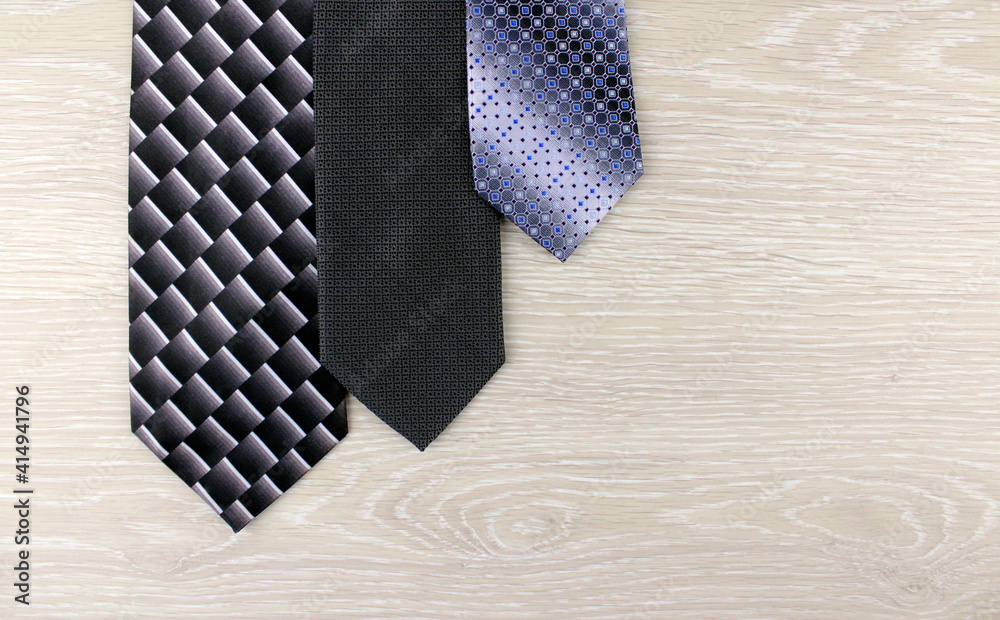 Three men's ties on a light wooden background Three men's ties on a light wooden background