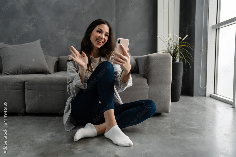 Beautiful young smiling woman sitting in a living room Beautiful young smiling woman sitting in a living room