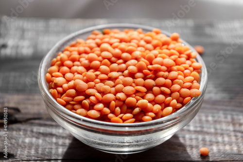 Red lentils in a glass bowl. Raw lentils.